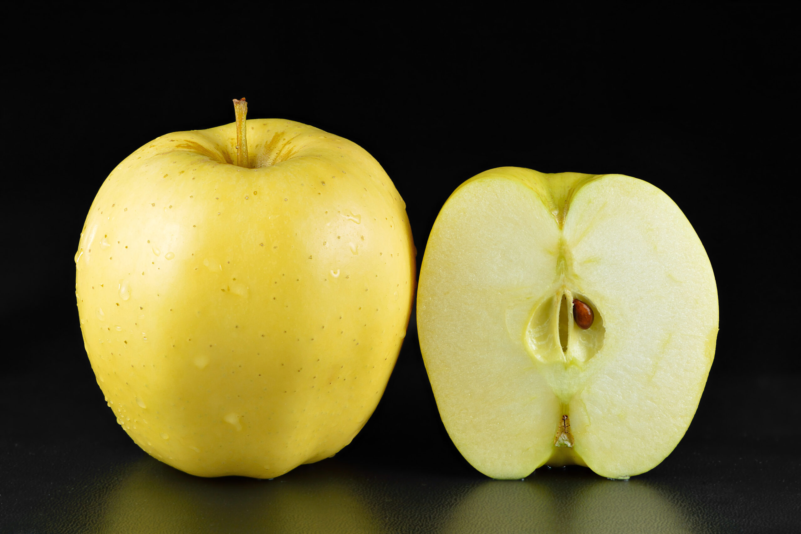Golden Delicious apple whole and halved
